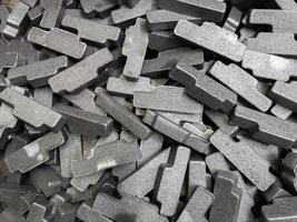 heap of gray steel forgings after shot blasting - close-up natural heavy industrial pattern with selective focus photo