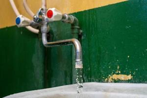 close-up view of old stained water tap with selective focus and background blur photo