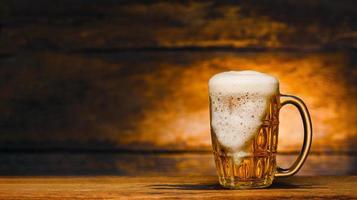 bodegón con vaso de cerveza en madera foto