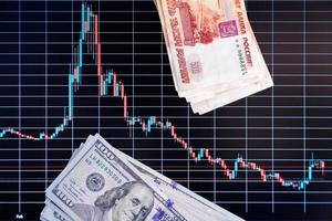 US dollar and russian ruble banknote stacks over digital screen with exchange chart, USD RUB depreciation concept, directly above view photo