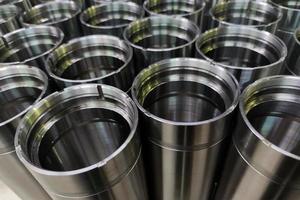 a close-up shot of shiny steel aerospace cnc turned tubes in a batch with selective focus and background blur photo