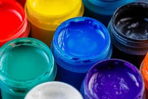 full-frame close-up background of opened small gouache paint jars photo