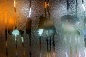 the word liar written on night wet window glass close-up with bokeh background photo