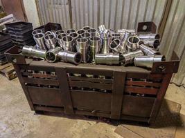 shiny steel parts overflowing big intermodal steel container box on factory floor photo