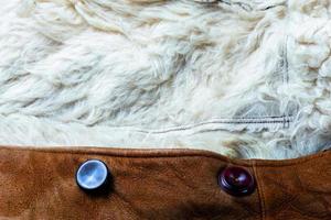 small brown thick seude jacket with white sheep fur lining closeup texture with selective focus and blur photo