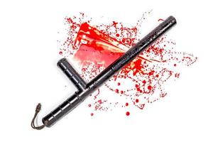 Bloody russian police rubber tonfa baton in blood spatter isolated on white photo