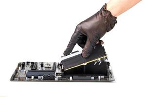 hand in glove installing memory module with heatsink in pc motherboard isolated photo