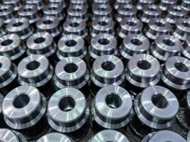 batch of shiny round steel parts background, close-up with selective focus photo