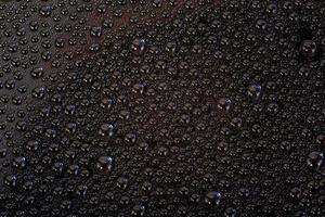 many small water drops on the black surface of cellphone hydriphobic coated glass screen photo