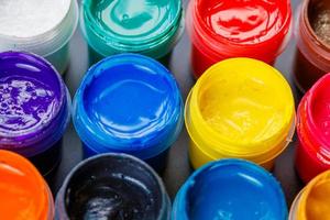 full-frame close-up background of opened small gouache paint jars photo