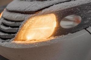 snow covered headlight of white or silver civiliian car photo