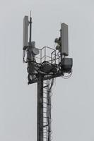 communication and gsm, wcdma, hspda and other 3g, 4g standarts tower close-up in cloudy weather photo