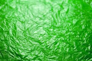 crumpled ufo green polyethilene film abstract background with selective focus photo
