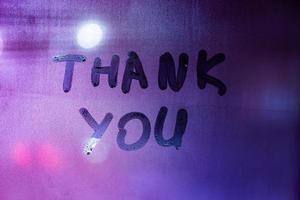 words thank you handritten on purple-blue night foggy window glass - closeup with selective focus photo