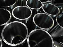dark industrial background with cnc machined shiny steel pipes - selective focus and lens blur tech photo