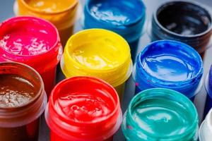 full-frame close-up background of opened small gouache paint jars photo