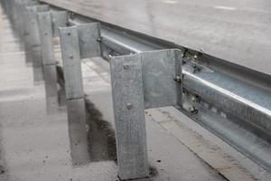 underscrewed nuts and bolts in highway road railing photo