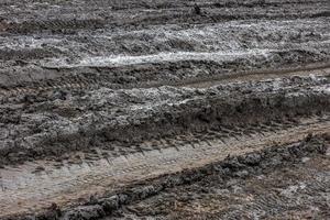 Wet dirt road after rain. Clay, dirt and soil at cloudy day light in autumn season. photo