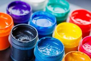 full-frame close-up background of opened small gouache paint jars photo