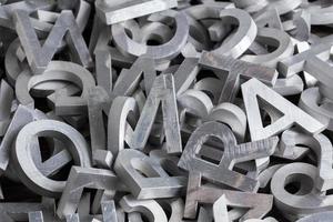 pile of silver metal alphabet characters cutted by waterjet machine photo