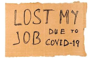 words lost my job due to covid-19 handwritten on rectangular flat sheet of cardboard - homeless placard, isolated on white background photo