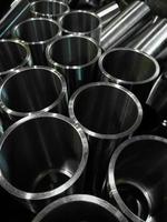 dark industrial background with cnc machined shiny steel pipes - selective focus and lens blur tech photo