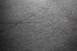 Abstract black scratched suface closeup selective focus background photo