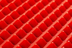 abstract red silicone pyramids array close-up background photo