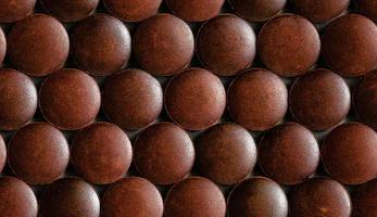 a seamless hexagonal pattern of many brown organic powder tablets laid tight in one layer on flat surface photo