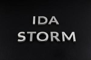 words ida storm laid with silver metal letters over dry black matte surface photo