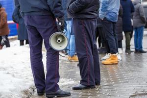 oficial de policía sosteniendo megáfono de altavoz al aire libre, primer plano foto