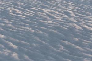 Primer plano de fondo de campo de nieve con enfoque selectivo bajo la luz solar directa de la noche foto