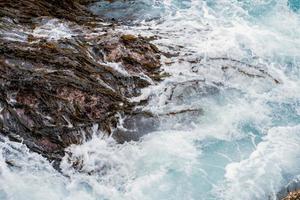 ola oceánica sobre rocas y algas foto