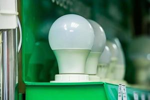 LED energy saving light bulb on green background. Samples of lamps in electronics store. Eco-friendly lifestyle. photo