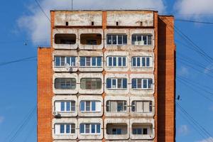 typical mid-russian concrete and brick high rise tower condominium residential building on blue sky background photo