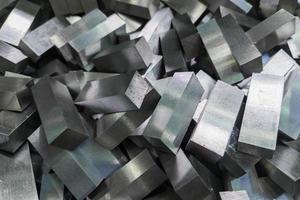 a pile of shiny faceted steel blocks - full frame close-up with selective focus photo