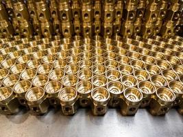 an abstract industrial close-up background of shiny brass metal threaded hexagonal fitting parts photo