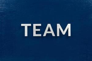 the word team laid with aluminium letters on dark-blue flat background photo