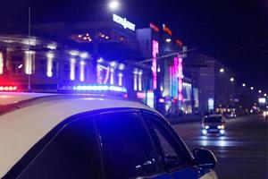 luces de coches de policía en la ciudad nocturna con enfoque selectivo y bokeh foto