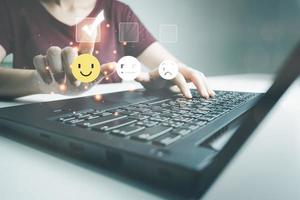 Concept of customer satisfaction and service, businesswoman using laptop to express their opinions, answers and satisfied scores. photo