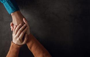 concepto de salud mental. pareja haciendo un toque de mano cómodo para alentar juntos. amor y cuidado. vista superior foto