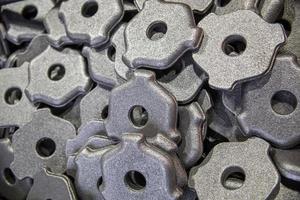 full frame pile of gray steel forgings after shot blasting - close-up natural heavy industrial pattern with selective focus photo