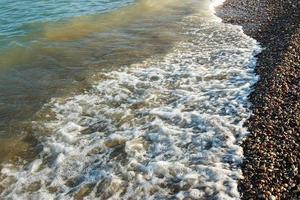 Sea shore with round stones on the mediterranean coast. Horizontal image. photo