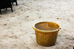 una cesta de basura en la playa para que el medio ambiente no se contamine con basura foto