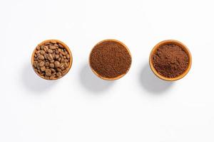 Three cups of coffee beans, ground coffee and cocoa for comparison. photo