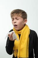 The child sneezes into a handkerchief, symptoms of colds. photo