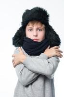 retrato de un niño de fondo blanco con un sombrero con orejas y una bufanda. foto