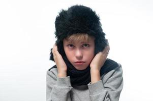 Portrait of upset guy in winter hat and scarf, cold winter and crisis time. photo