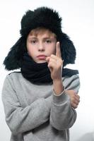 retrato de un niño de fondo blanco con un sombrero con orejas y una bufanda. foto