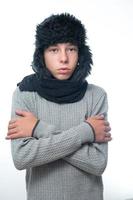 Portrait of upset guy in winter hat and scarf, cold winter and crisis time. photo